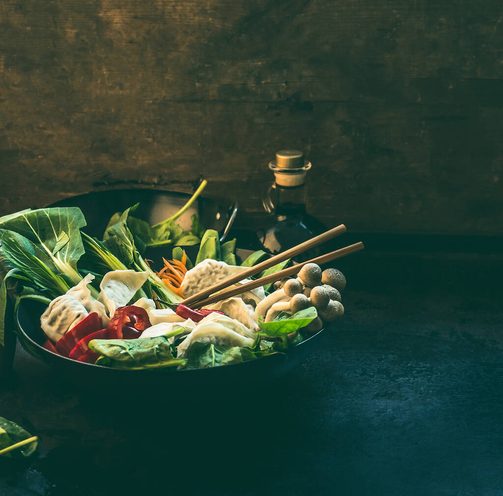 Asya yemekleri. Koreli vejetaryen tenceresi için rengarenk malzemelerle dolu bir tava. Koyu mutfak masasında güveç hazırlığı. Sağlıklı vejetaryen yemekleri ve yemekleri. - Fotoğraf, Görsel