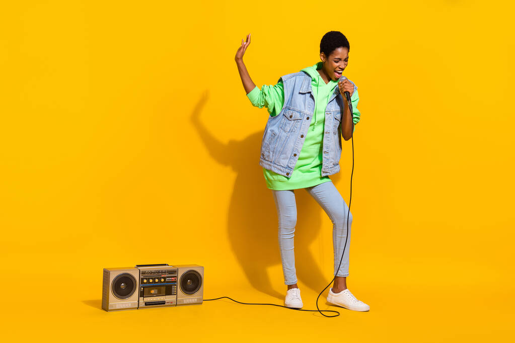 Retrato de tamaño completo de la chica divertida excitada mantenga el entretenimiento de voz de karaoke de micrófono aislado sobre fondo de color amarillo. - Foto, imagen