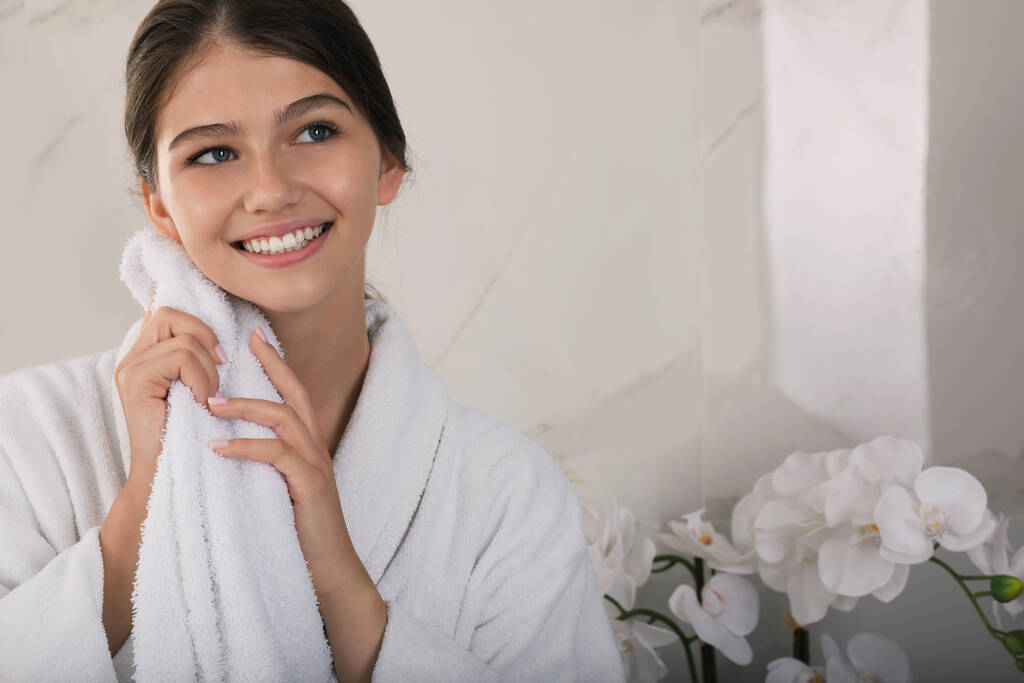 Hermosa chica adolescente limpiando la cara con toalla en casa, espacio para el texto - Foto, Imagen