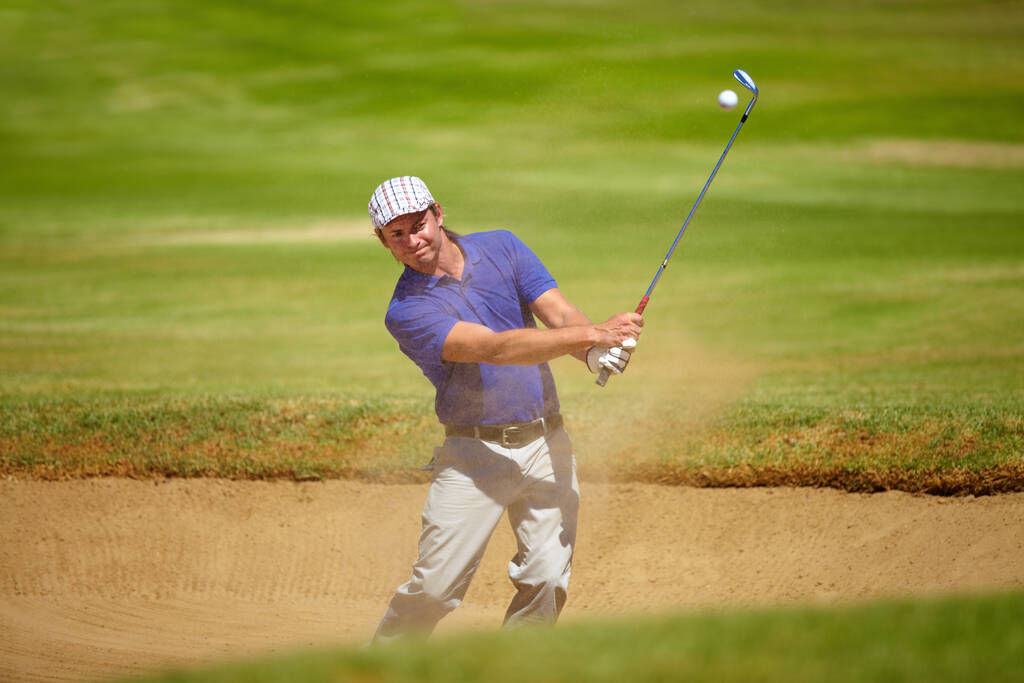 Niezła ucieczka. kaukaski golfista bujający się z piaskowej pułapki - Zdjęcie, obraz
