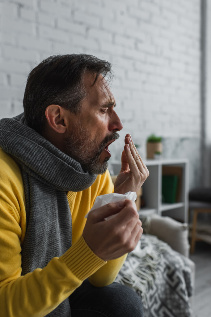 больной человек с пневмонией сидит в теплом шарфе и кушетка дома - Фото, изображение
