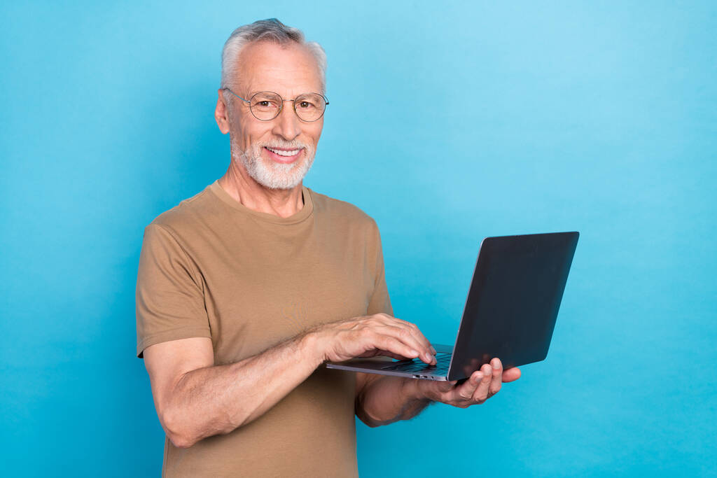 Zdjęcie atrakcyjne inteligentny człowiek nosić modny pastel uczy się używać netbook urządzenie gadżet puste miejsce izolowane na niebieskim tle koloru. - Zdjęcie, obraz
