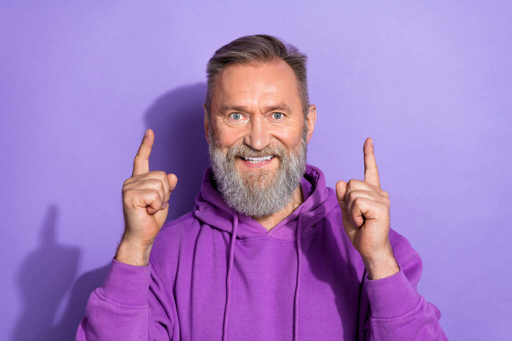 Foto de primer plano de edad avanzada hombre barbudo guapo dedos encima de la publicidad positiva aislado en el fondo de color púrpura. - Foto, Imagen