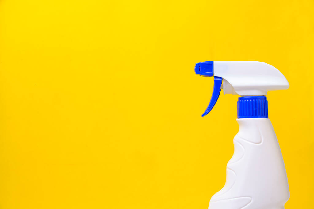Sprayer zum Waschen von Fenstern und Sanitär gelben Hintergrund - Foto, Bild