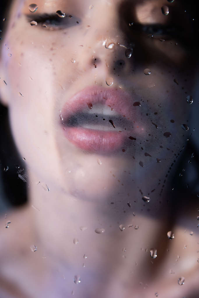Homályos nő lélegzik nedves üveg szürke háttér  - Fotó, kép