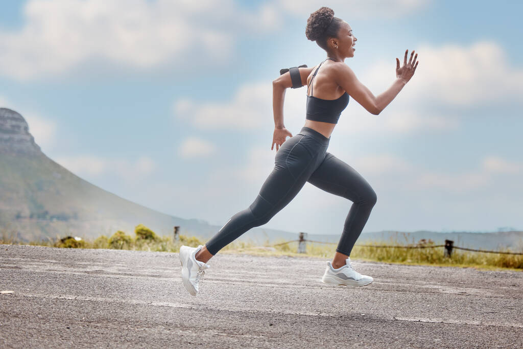 Jedna africká americká atletka vypadala soustředěně, zatímco se chystala běhat, aby zvýšila své srdce a vytrvalost. Mladá černoška běžela ven, aby zvýšila rychlost a tempo. Fitness je životní styl. - Fotografie, Obrázek