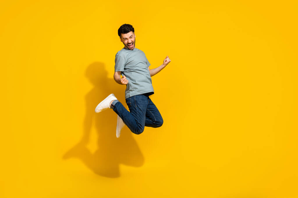Full size ritratto di felicissimo persona che salta pugni rtaise celebrare isolato su sfondo di colore giallo. - Foto, immagini