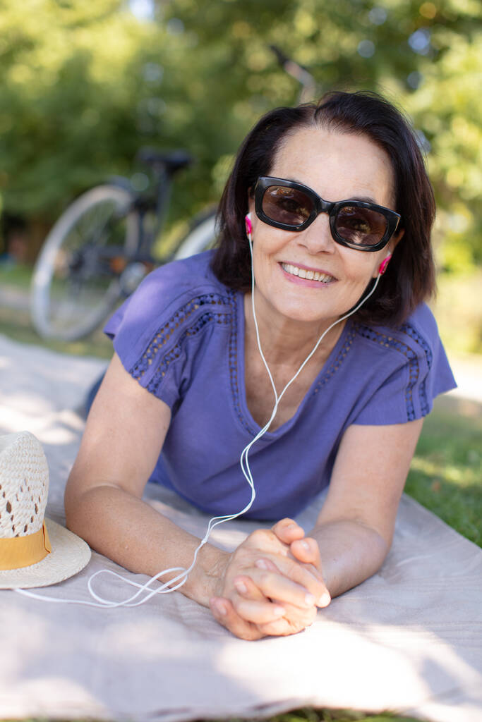 relaxed pensioner listening to music in nature - Photo, Image