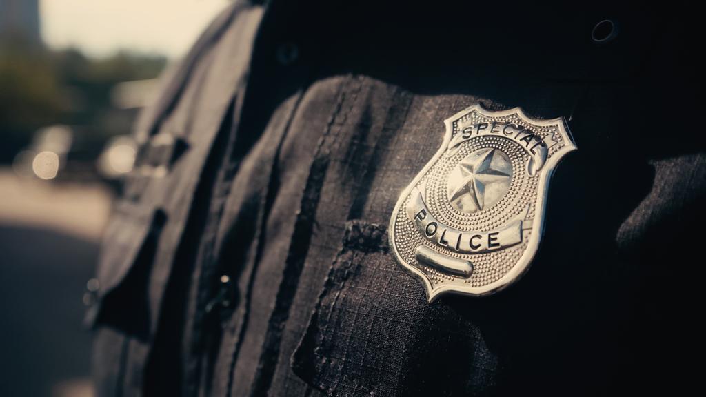 special police lettering on silver badge and black uniform of cropped policeman  - Photo, Image