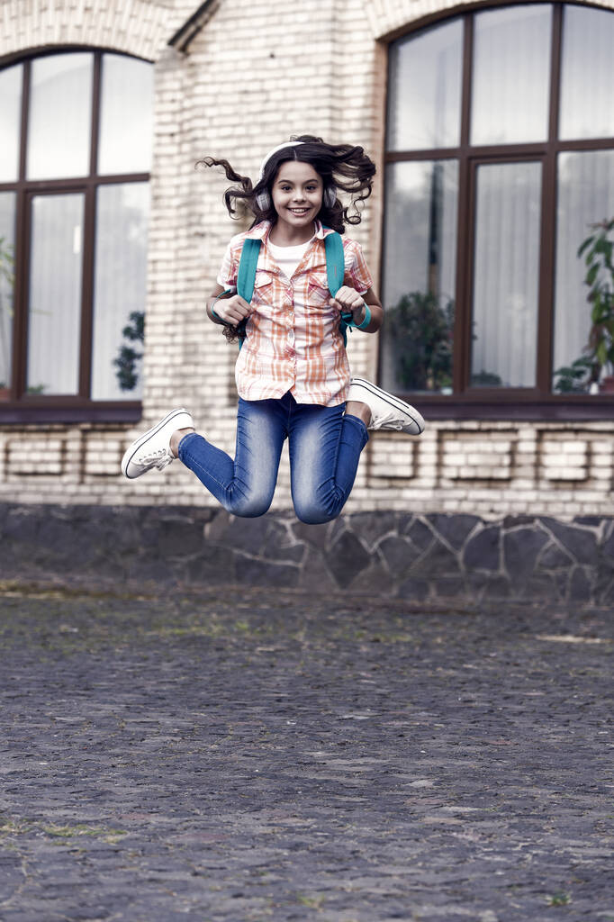 Щасливий дитячий день. Енергійний стрибок дитини в шкільному дворі. Шкільна освіта. Міжнародний дитячий день. 20 листопада. Щасливе дитинство, що веде до майбутнього
. - Фото, зображення