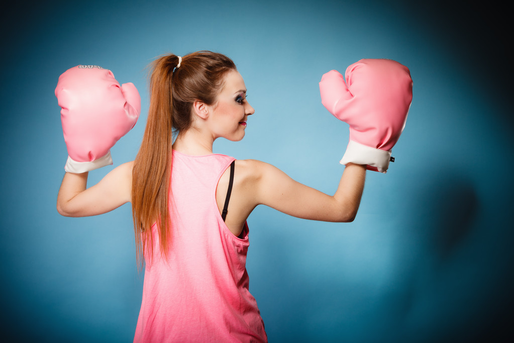 大きな楽しいピンクの手袋を身に着けている女性のボクサー - 写真・画像