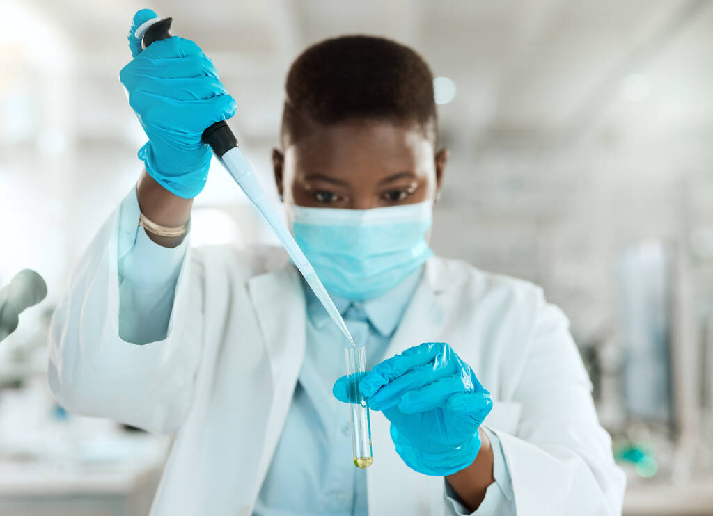 Poco a poco. una joven científica sentada sola en su laboratorio y analizando la orina - Foto, imagen