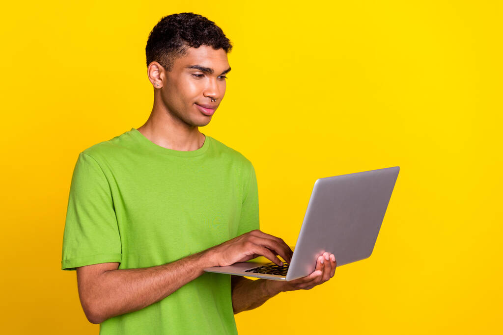 Photo de jeune bel utilisateur professionnel confiant détiennent nouveau ordinateur portable concentrée marché isolé sur fond de couleur jaune. - Photo, image