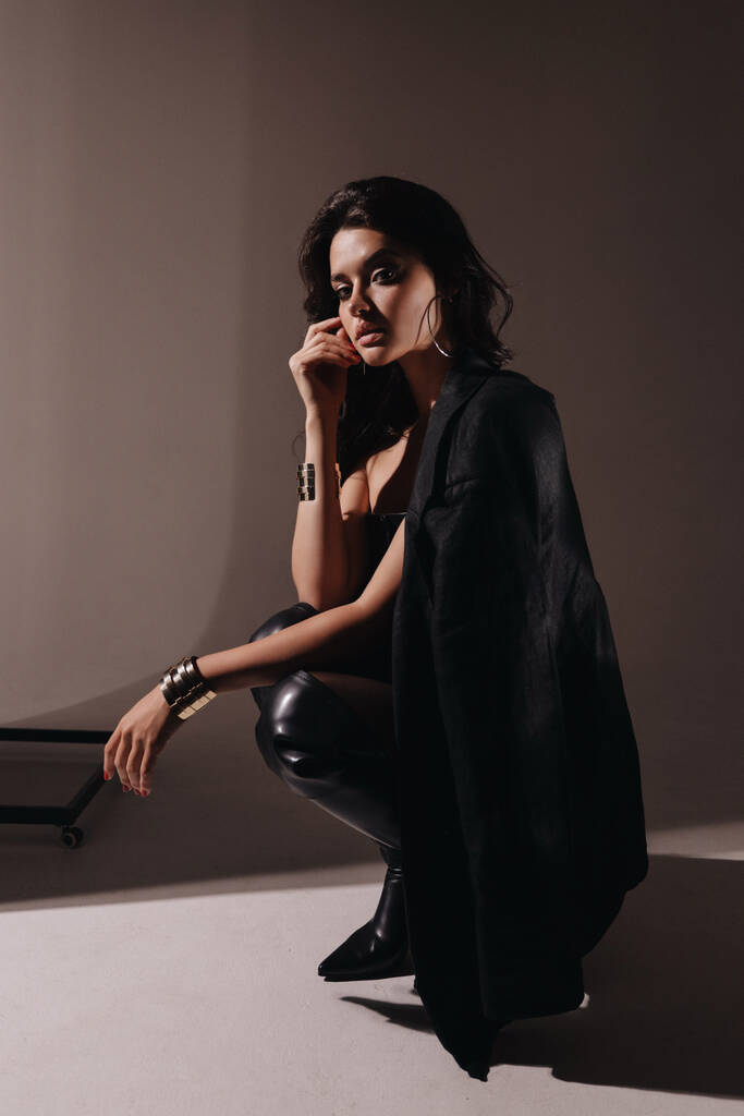 moda odkryty zdjęcie pięknej kobiety z ciemnymi włosami w eleganckiej czarnej bieliźnie i kurtce pozowanie w studio - Zdjęcie, obraz