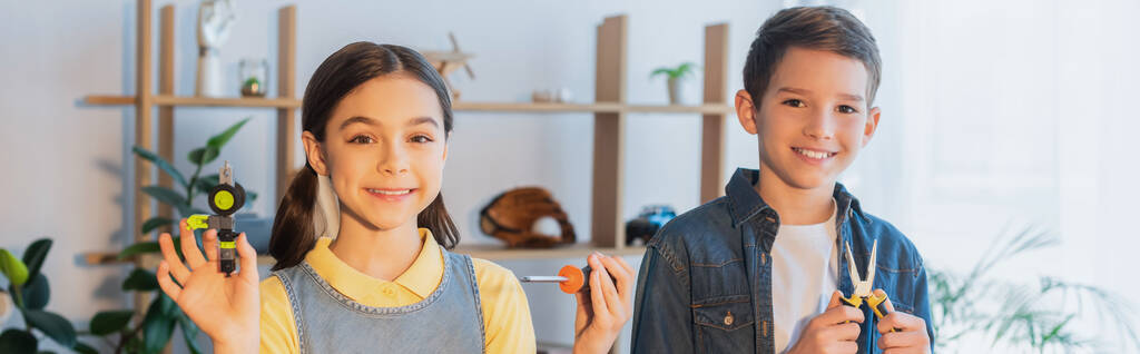 happy kids with tools and mechanical part smiling at camera at home, banner - Photo, Image