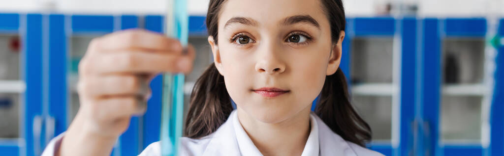preteen κορίτσι κρατώντας θολή σωλήνα δοκιμής στο εργαστήριο χημικών, πανό - Φωτογραφία, εικόνα