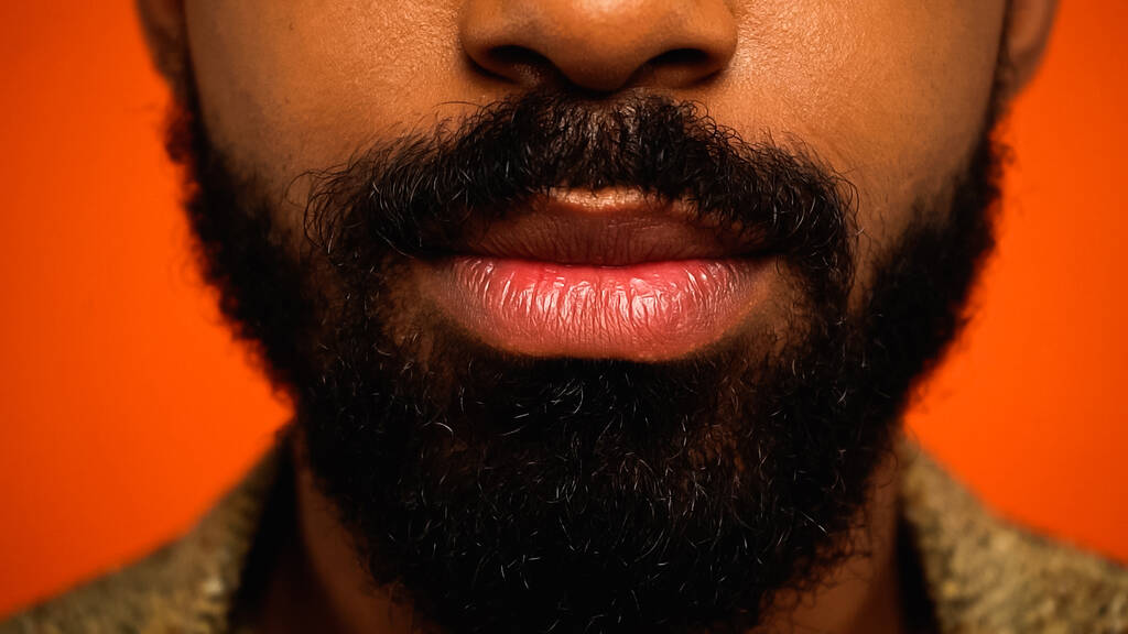 close up de homem afro-americano cortado e barbudo isolado em laranja  - Foto, Imagem
