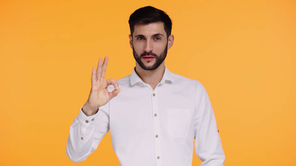 bearded man in white shirt showing ok sign isolated on yellow - Photo, Image
