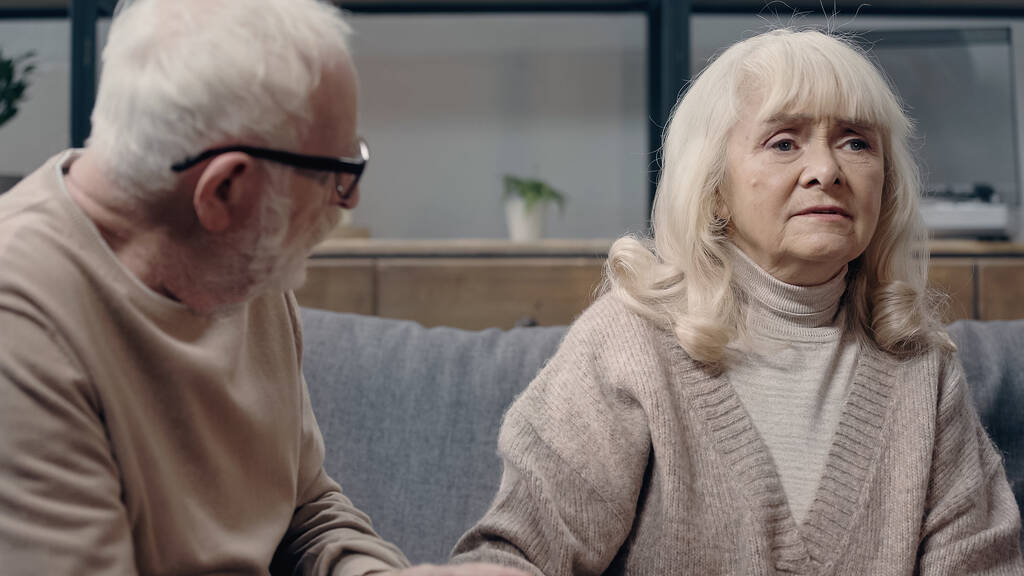Старший чоловік в окулярах дивиться на заплутану дружину з деменцією
  - Фото, зображення