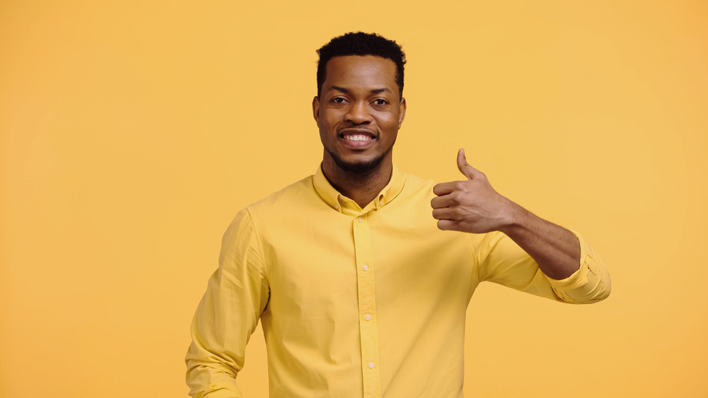 positiivinen afrikkalainen amerikkalainen mies paita osoittaa kuin eristetty keltainen  - Valokuva, kuva