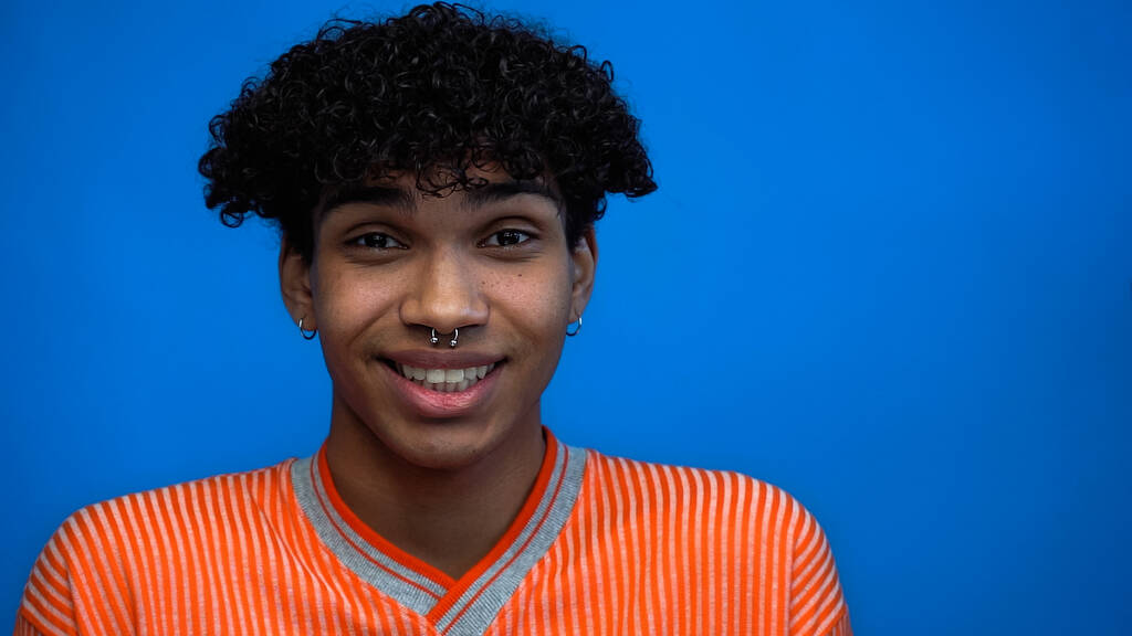 Jeune homme afro-américain souriant à la caméra isolé sur bleu  - Photo, image