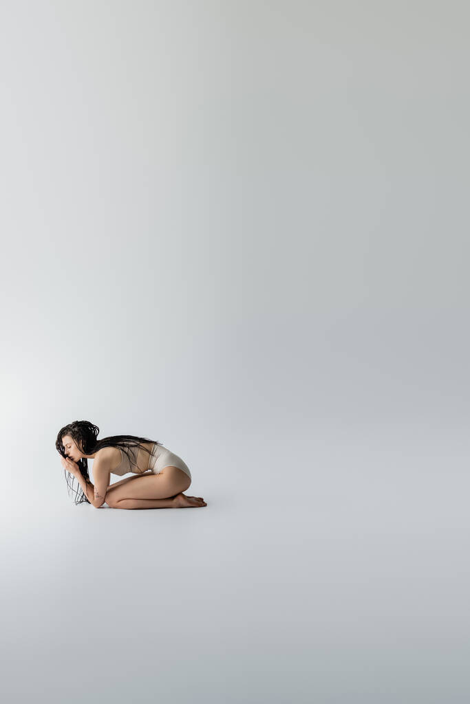 Side view of slim model in underwear posing on grey background  - Photo, Image