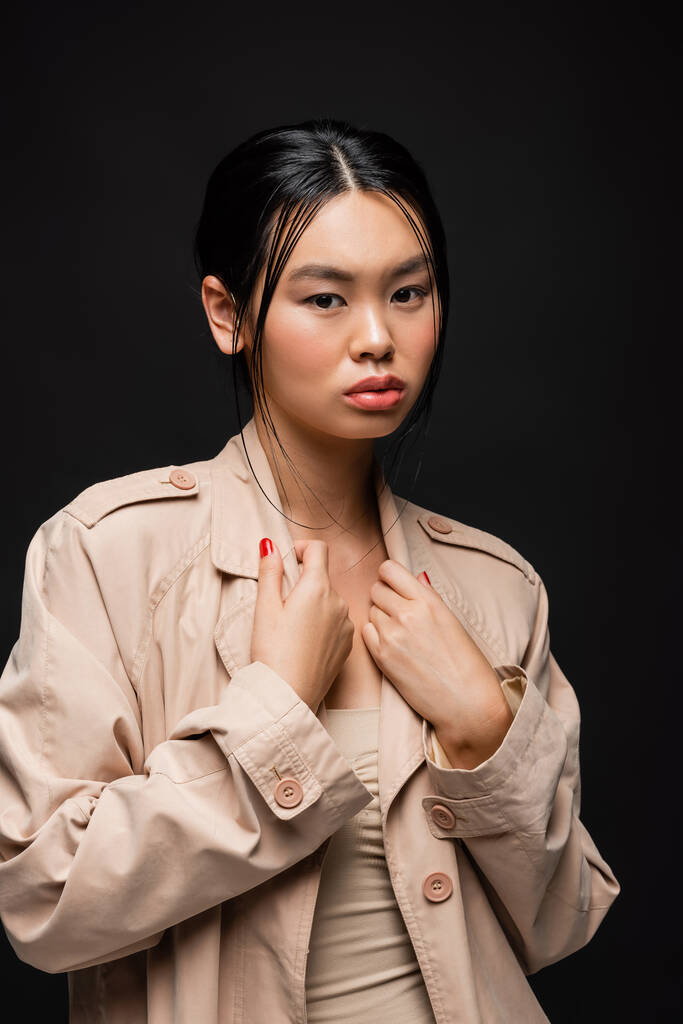 moda asiatico donna toccare trench isolato su nero  - Foto, immagini