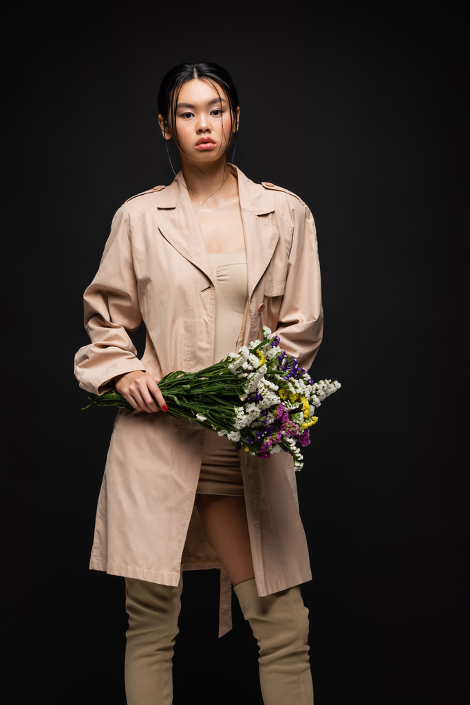 Divatos ázsiai modell ruha és ballonkabát gazdaság csokor elszigetelt fekete  - Fotó, kép