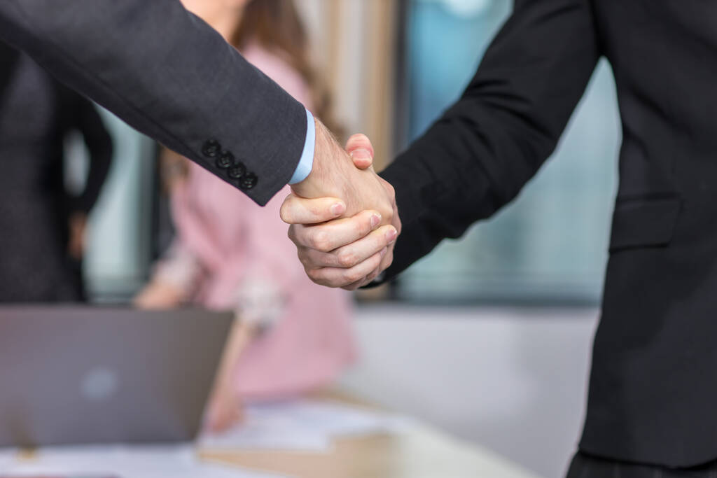Geschäftsleute schütteln Hände. Geschäftsmann und Geschäftsfrau beim Händeschütteln während eines Meetings im Büro - Foto, Bild