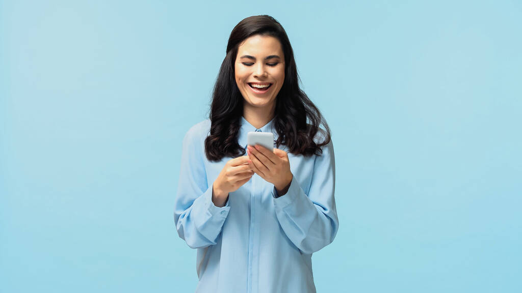 iloinen nuori nainen paita messaging älypuhelimeen eristetty sininen - Valokuva, kuva