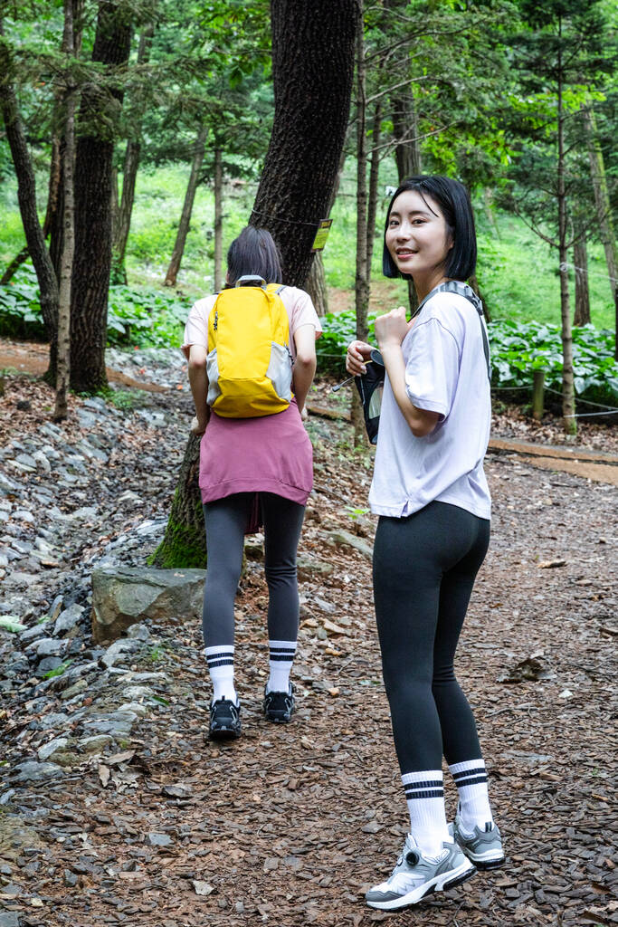 Koreli genç kadınlar dağ yürüyüşü yapıyor ve çarpışıyor. - Fotoğraf, Görsel