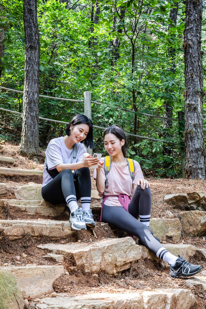 korealainen nuoret naiset vaellus ja plogging _ istuen katsomassa älypuhelin - Valokuva, kuva