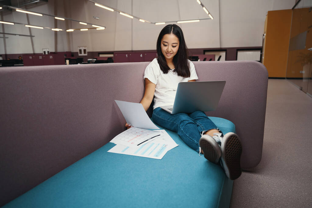 Ganztägiges Porträt der eleganten Unternehmerin arbeitet am Laptop, während das gesamte Dokument ist der moderne Arbeitsplatz - Foto, Bild