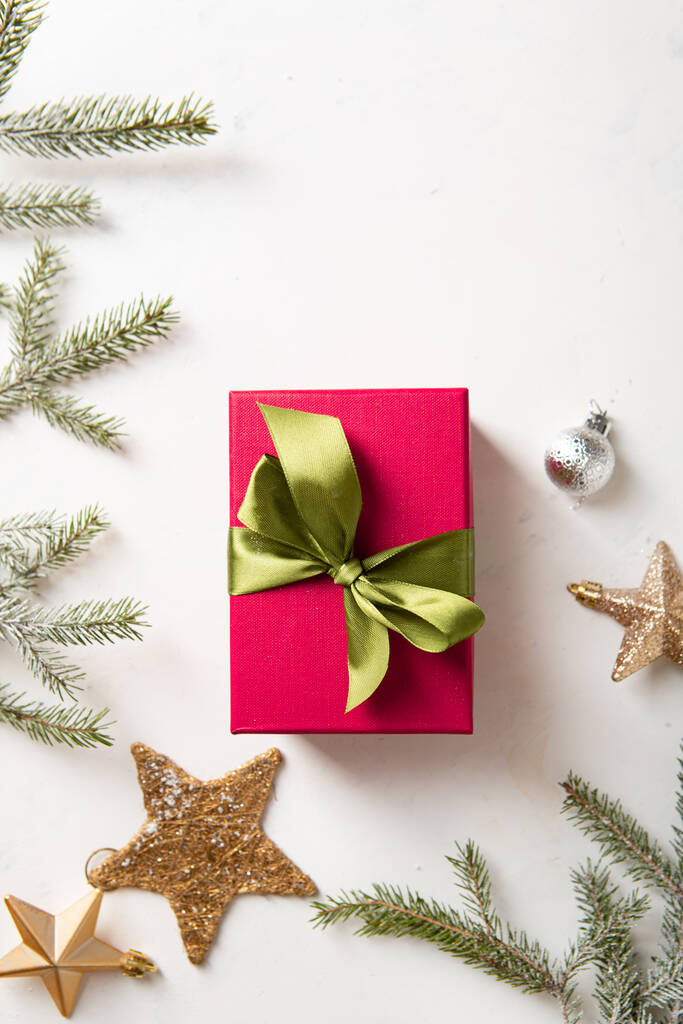 Horní pohled na červený dárek Vánoční box na lehkém povrchu a dekorace  - Fotografie, Obrázek