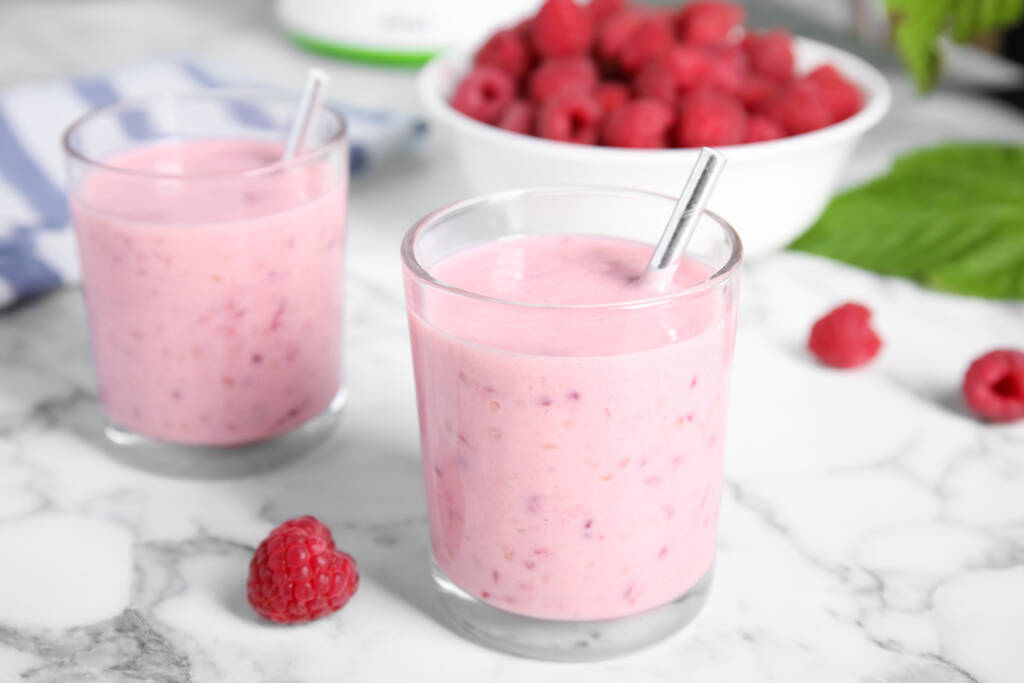 Tasty fresh raspberry smoothie on white marble table - Fotoğraf, Görsel