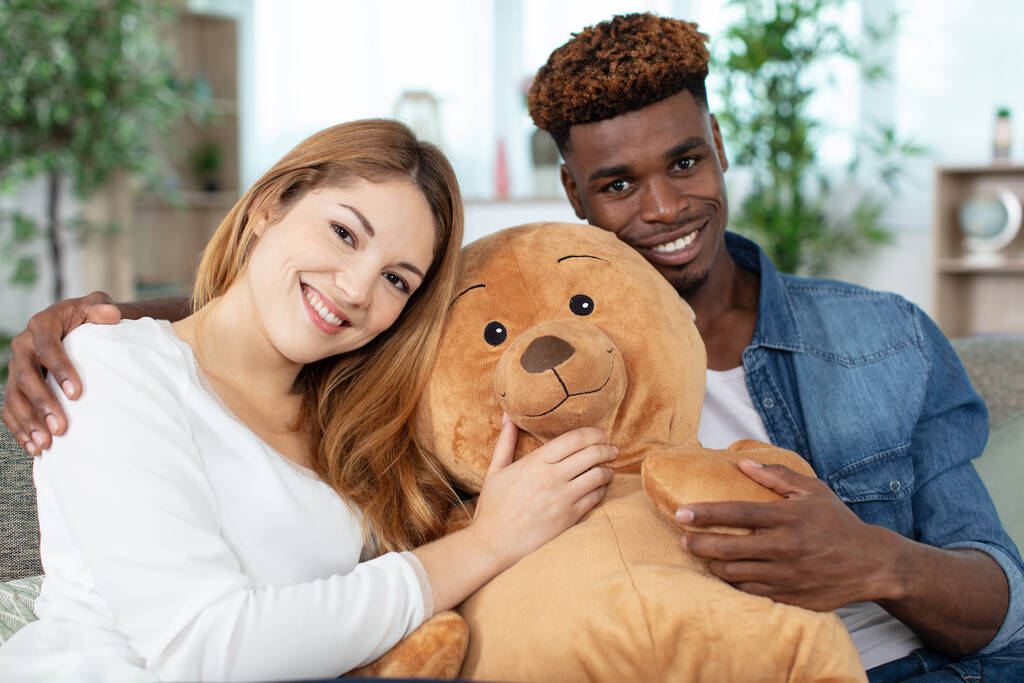 couple discussing while holding teddy bear at home - Photo, Image