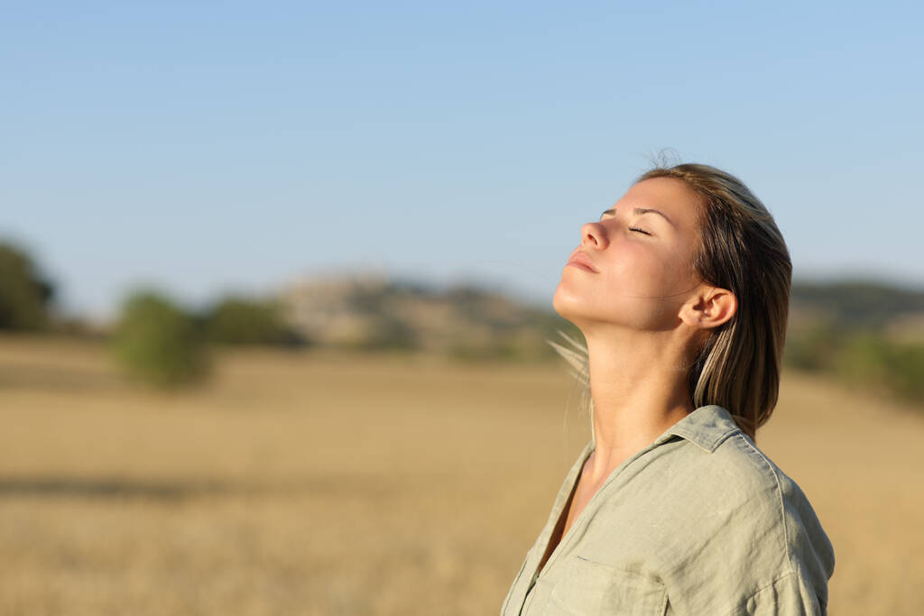 Beautiful woman breathing fresh air in a rural field - Photo, Image