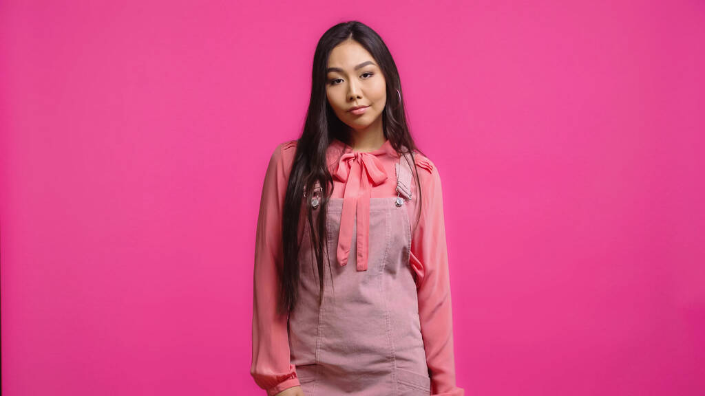 scontento e giovane donna asiatica guardando la fotocamera isolata sul rosa  - Foto, immagini