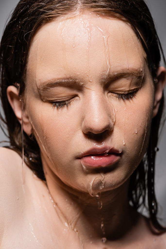 lähikuva vettä valuu alas kasvot nuori malli eristetty harmaa  - Valokuva, kuva