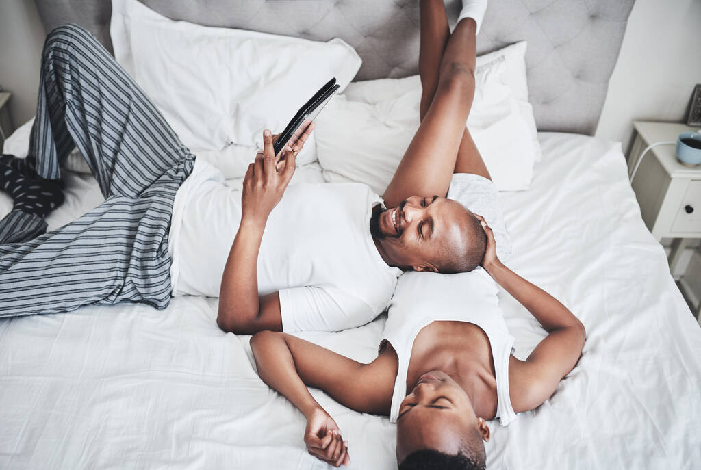Odpočinek nikdy nebyl tak uvolněný. šťastný mladý pár pomocí digitální tablet v ložnici doma - Fotografie, Obrázek