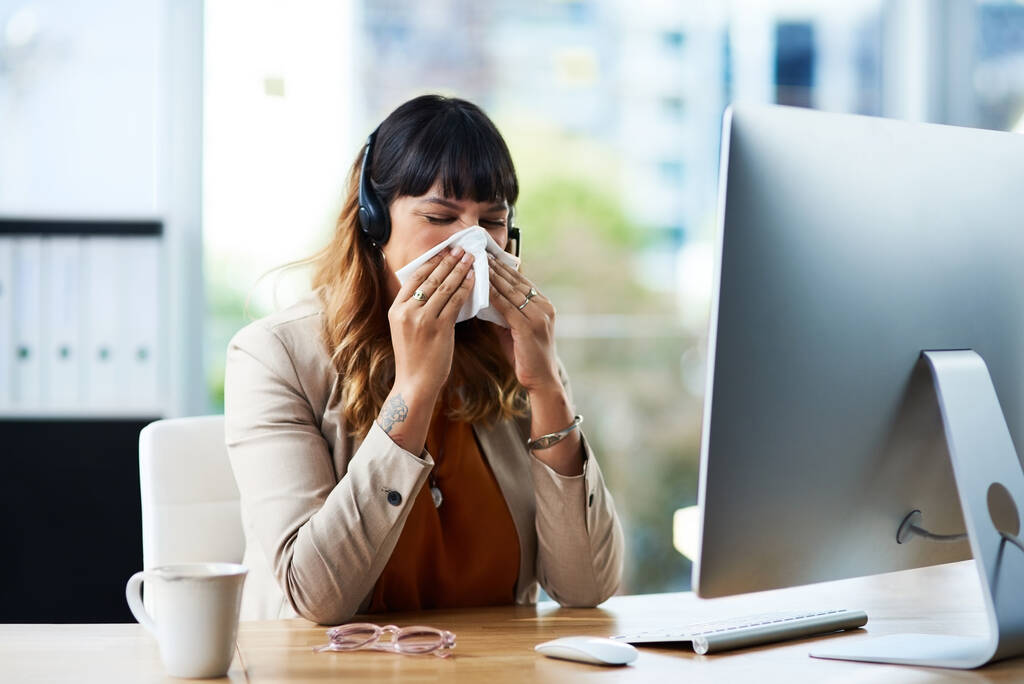 Oh nee, ik moet griep hebben. een aantrekkelijke jonge zakenvrouw die lijdt aan een verkoudheid en snuit haar neus terwijl in haar kantoor - Foto, afbeelding