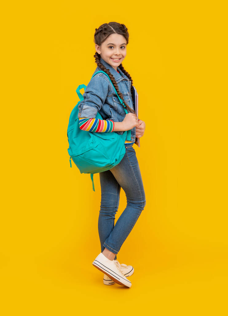 Sırt çantası taşıyan mutlu bir kız, eğitim. Genç kız sarı arka plan. Okul eğitimi. Resmi olmayan ve gayri resmi eğitim. - Fotoğraf, Görsel