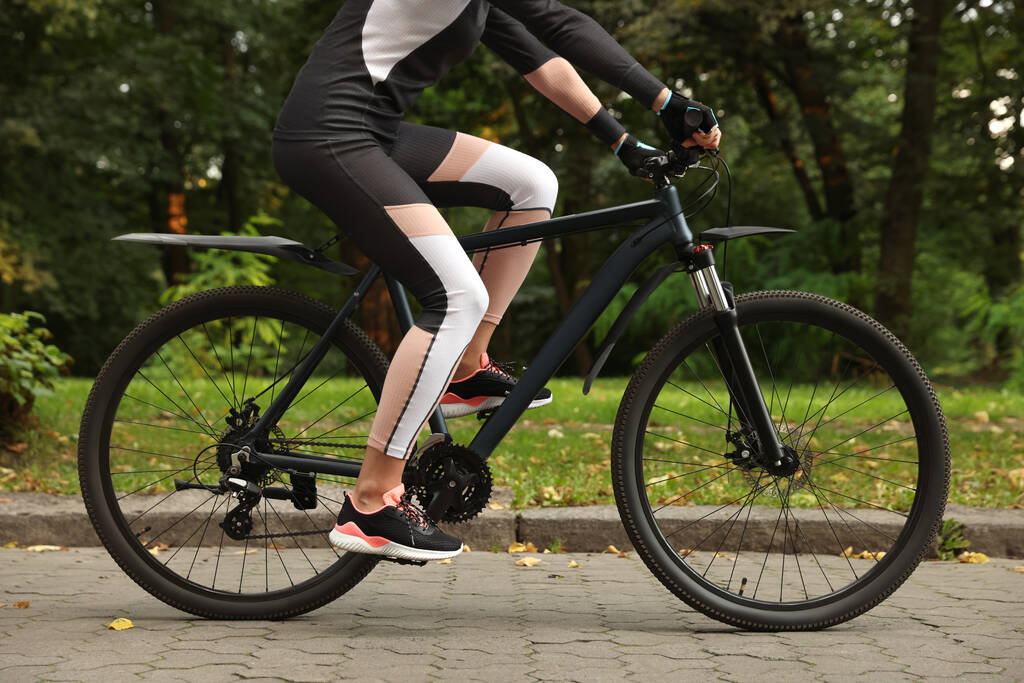 Молода жінка їде на велосипеді на вулиці, крупним планом
 - Фото, зображення