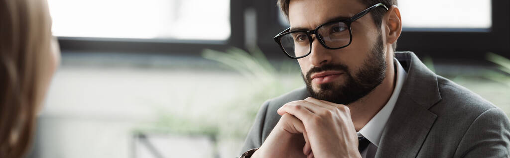 Uomo d'affari in occhiali e abbigliamento formale guardando candidato offuscata sul colloquio di lavoro, banner  - Foto, immagini