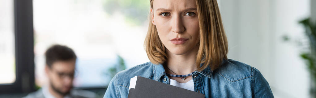 Mujer molesta con curriculum vitae mirando a la cámara en la oficina, pancarta  - Foto, imagen