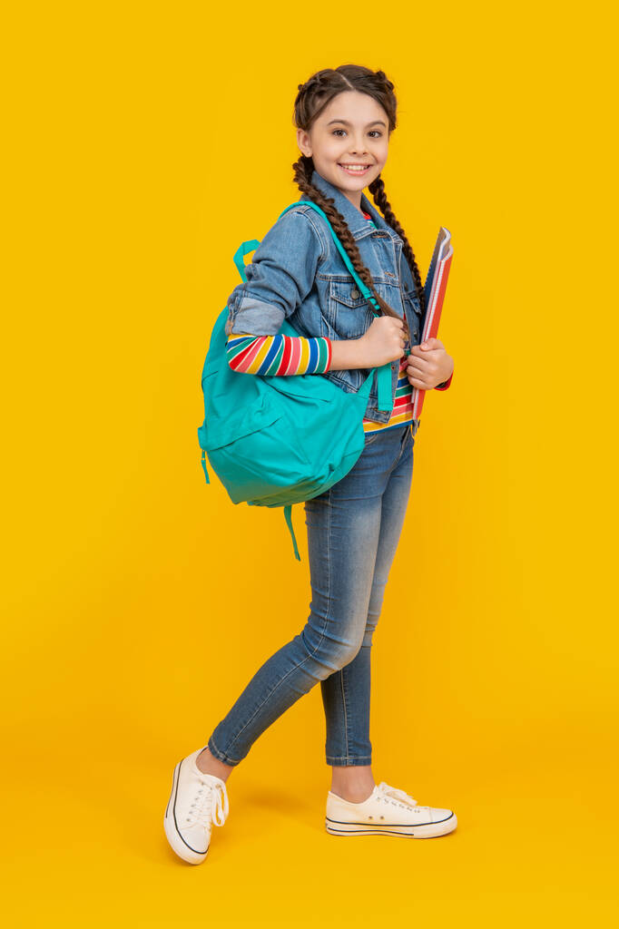 Happy schoolgirl yellow background, school. Teenage girl back to school. September 1. School education. - Photo, Image