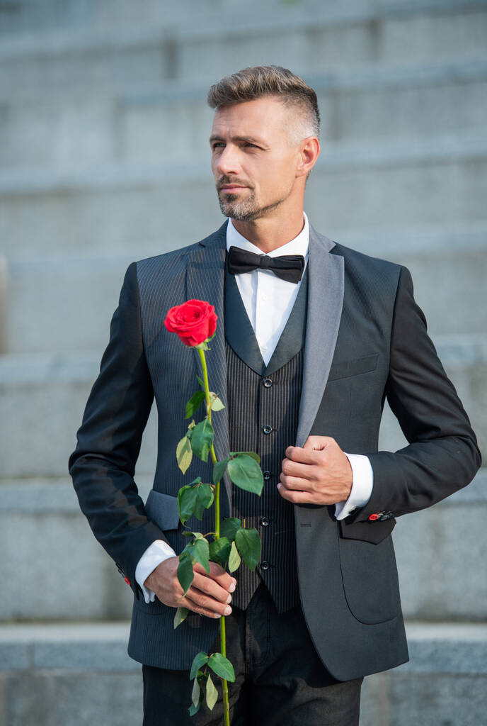 Konzept für besondere Anlässe. eleganter Mann mit Rose für besondere Anlässe. Bräutigam zu besonderen Anlässen. - Foto, Bild