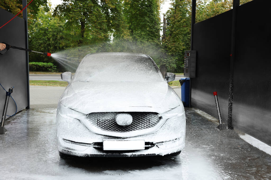 Man wassen auto met hoge druk water jet bij car wash, close-up - Foto, afbeelding