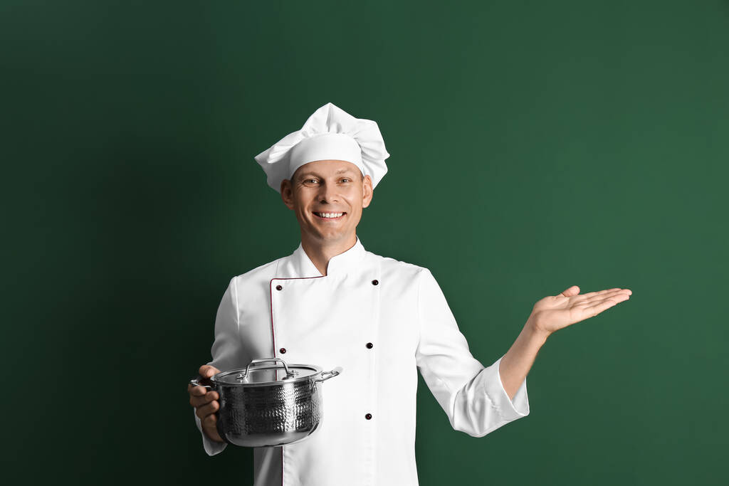 Boldog férfi séf főzés pot sötét zöld háttér - Fotó, kép