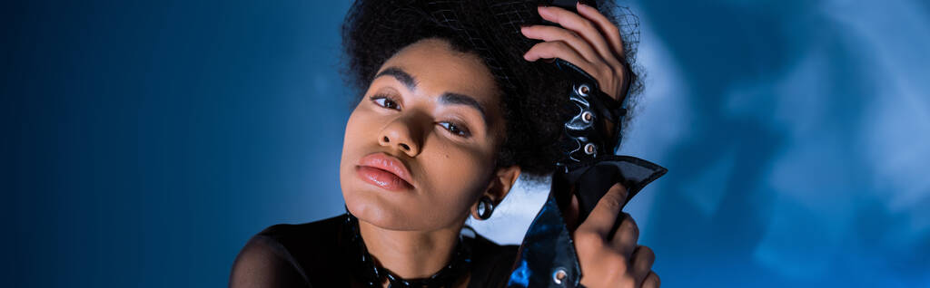 stylowa Afroamerykanka w koronkowych skórzanych rękawach na niebieskim, sztandar - Zdjęcie, obraz